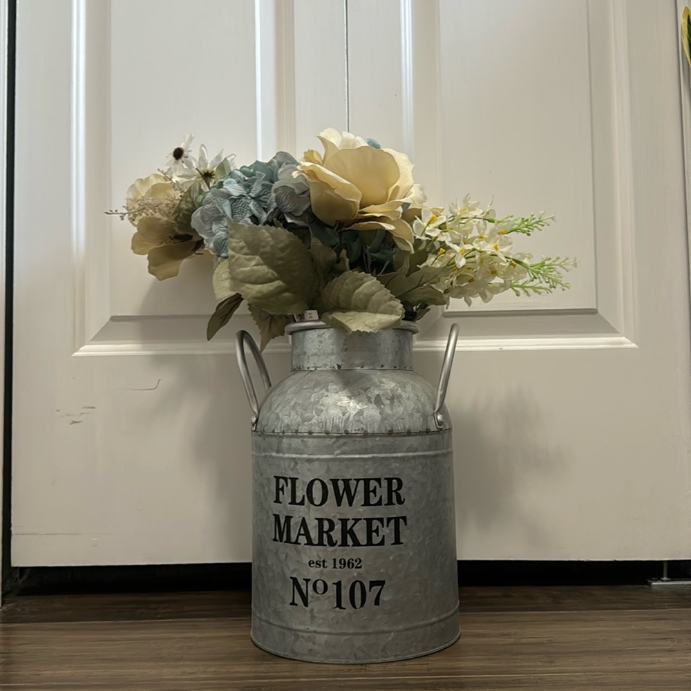 Fake flowers in a silver bucket